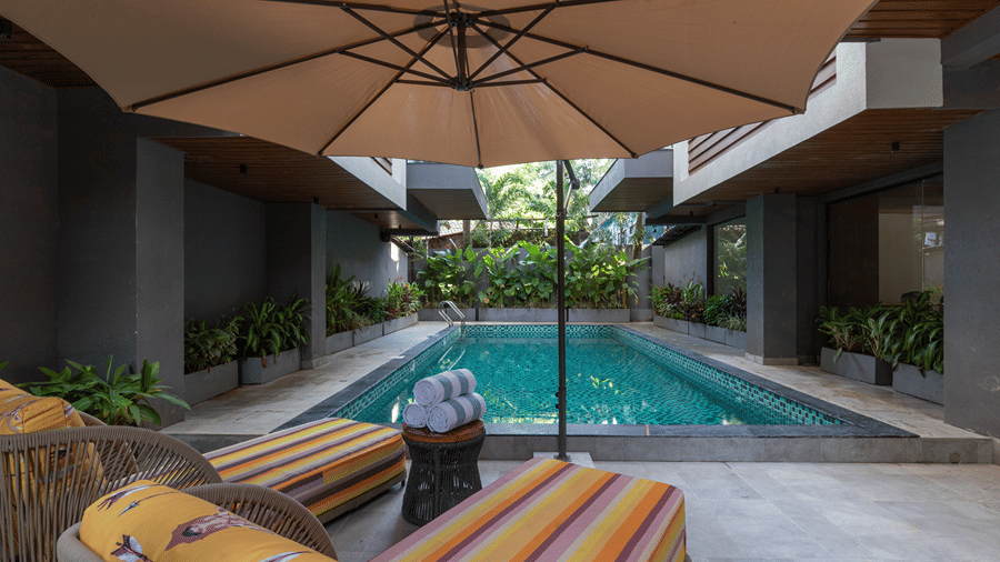 Outdoor central swimming pool with sun loungers, parasols, and courtyard architecture at Sibaya Courtyard By Stone Wood Premier.