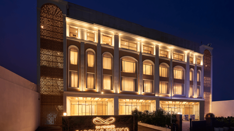 Dramatically lit contemporary hotel façade at night with geometric architectural detailing