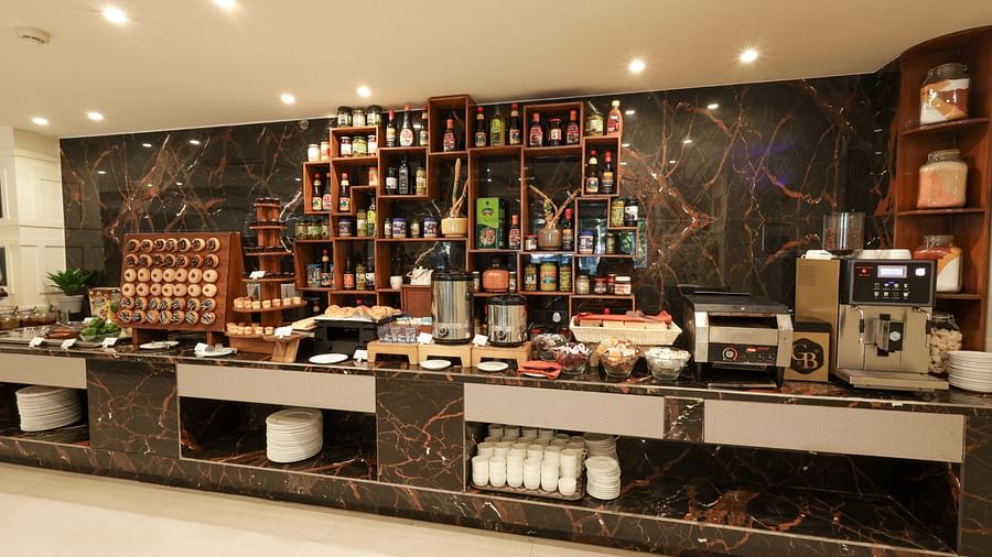 Cafe featuring a coffee maker on the tabletop and doughnuts at Sobit Sarovar Portico, Goa