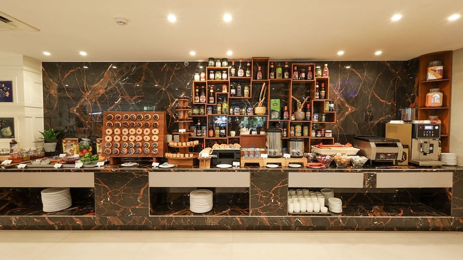 Cafe featuring a coffee maker on the tabletop and doughnuts at Sobit Sarovar Portico, Goa