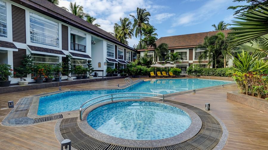 Swimming pool surrounded by greenery at Sobit Sarovar Portico, Goa