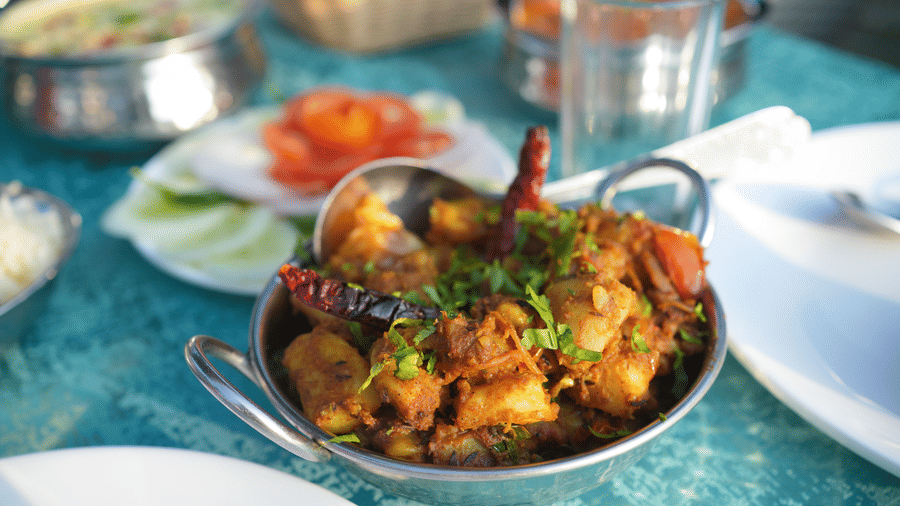 A close up shot of an Indian potato based dish in a serving bowl | Sol Glow Resort, Nainital