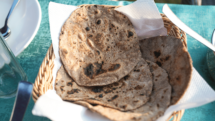 A bunch of Indian breads placed on a sewn wooden basket | Sol Glow Resort, Nainital