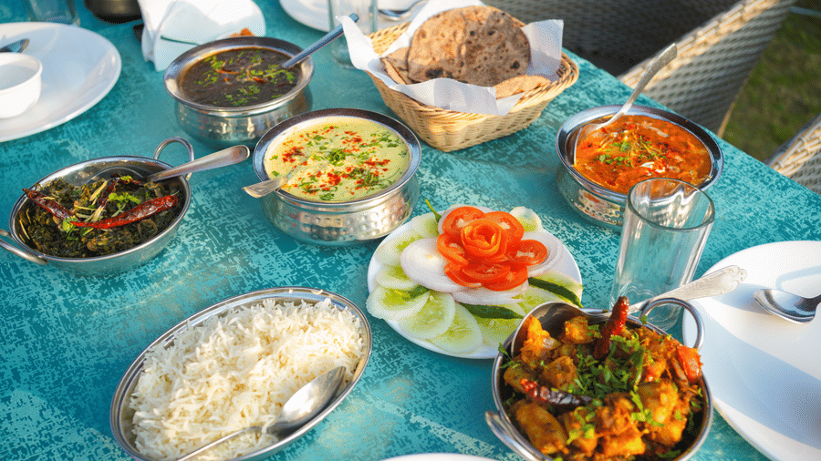A creatively plated line of Indian dishes on a table | Sol Glow Resort, Nainital
