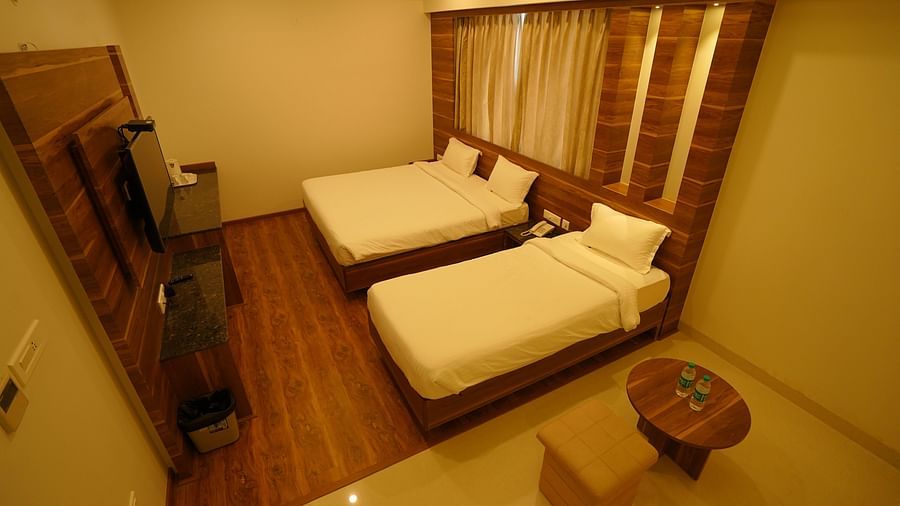 A double bed and a single bed inside the premium triple room - Springs Hotel Tirupati