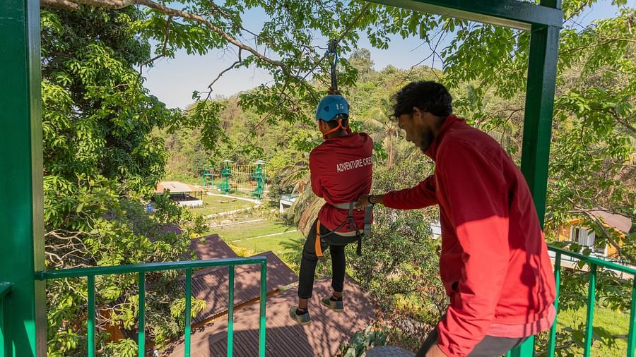 Image of a person balancing on a wooden bridge in an adventure park | Stone Wood Jungle Resort, Dandeli