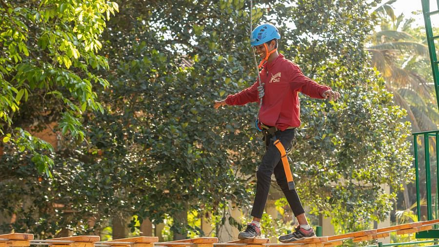 Image of a person climbing through a rope obstacle on an a | Stone Wood Jungle Resort, Dandelidventure course.