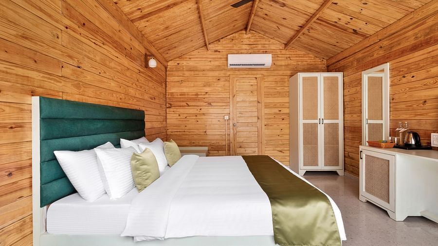 a double bed with pillows on it and a wardrobe on the side inside one of the rooms - Stone Wood Jungle Resort, Dandeli