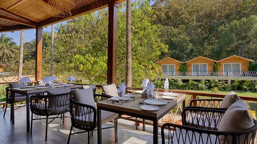 seating arrangements inside al fresco Dining with views outside the restaurant - Stone Wood Jungle Resort, Dandeli