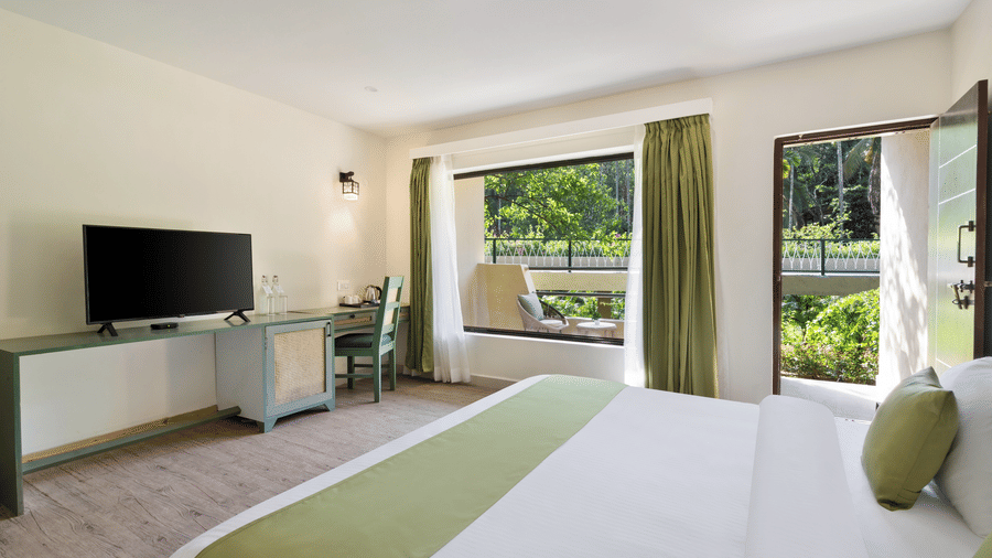 Spacious bedroom with large windows and modern interiors at Stone Wood Premier Dandeli, designed for a comfortable stay.