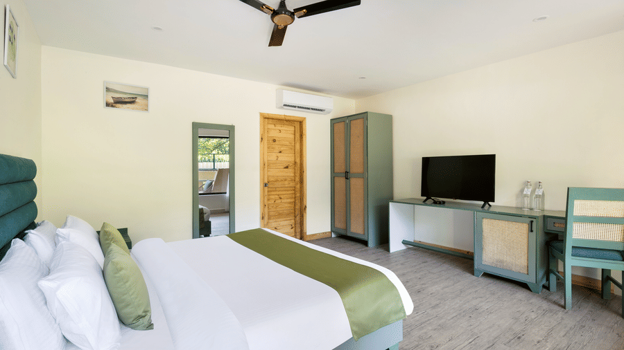 Well-appointed bedroom with double bed and amenities at Stone Wood Premier Dandeli, ideal for a relaxing getaway.