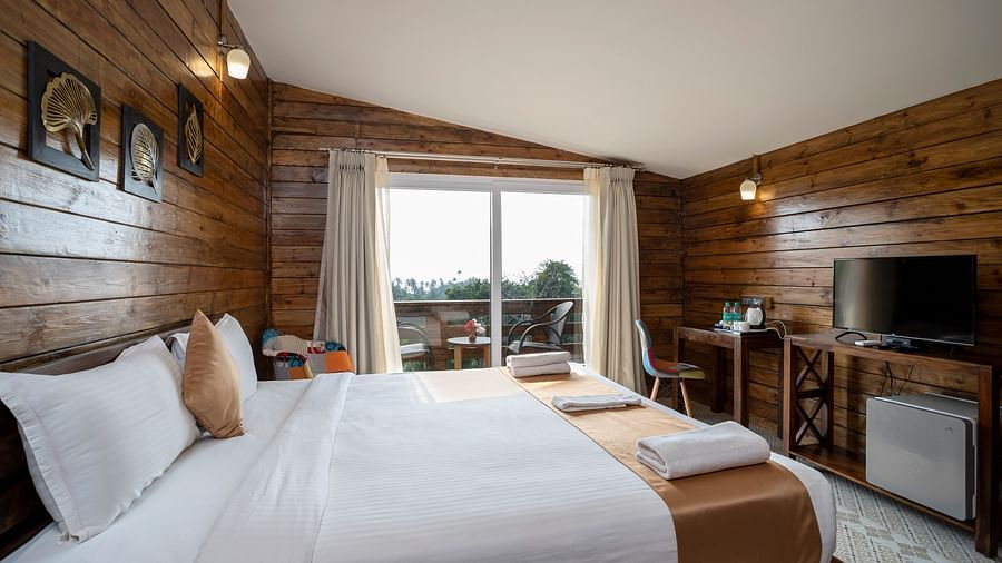 Cosy king-size bed with a serenic view from the window at Stone Wood Resort, Mandrem 