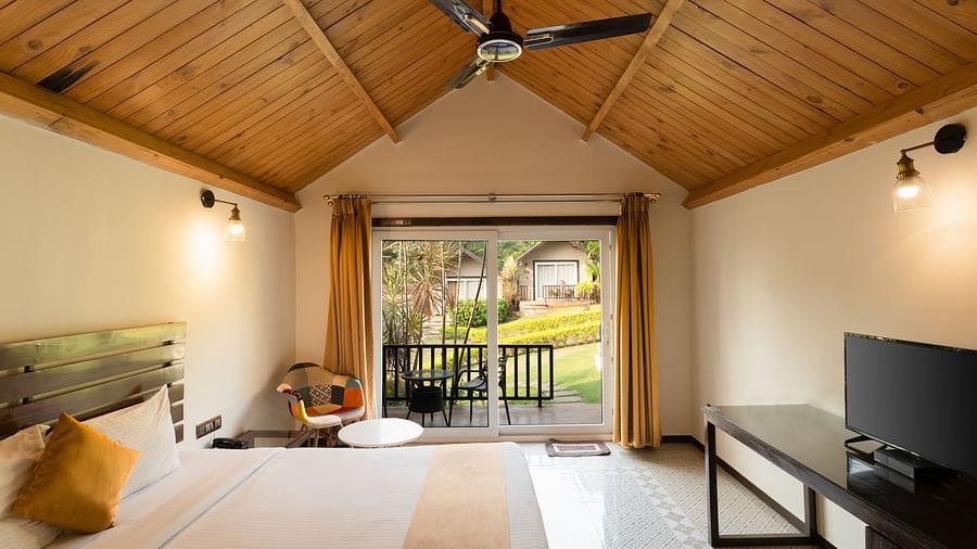 A cozy and comfortable bed beneath a wooden ceiling at Stone Wood Resort, Mandrem