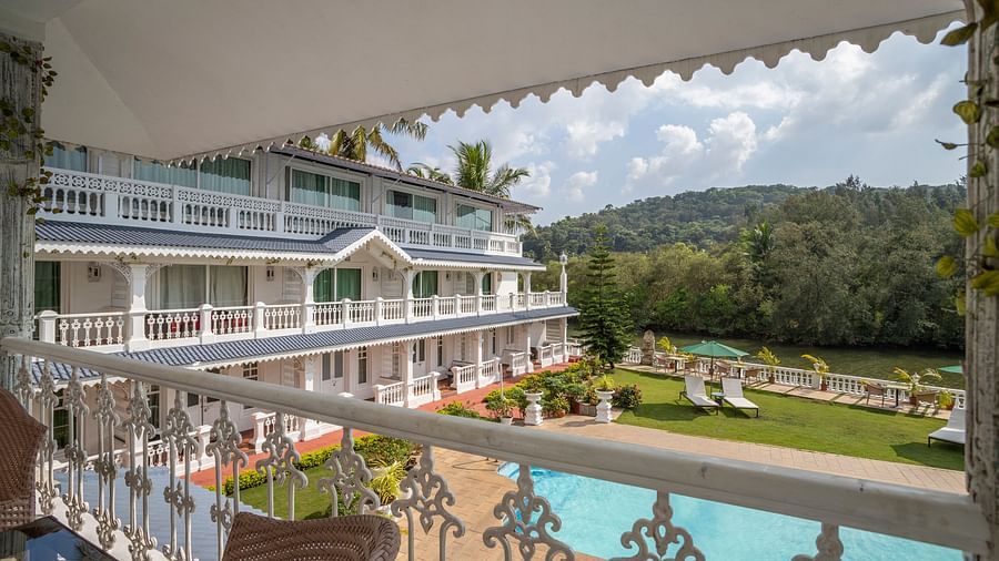 The Maharaja Balcony offers a splendid view of the facade, pool and thick vegetation surrounding the premise - Stone Wood Riverfront Resort, Siolim