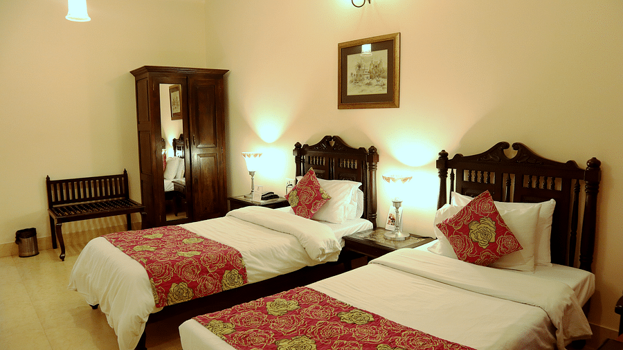 Twin beds with beautiful red bedsheets and red pillow covers at Junior Suite at Suryaa Villa Jaipur