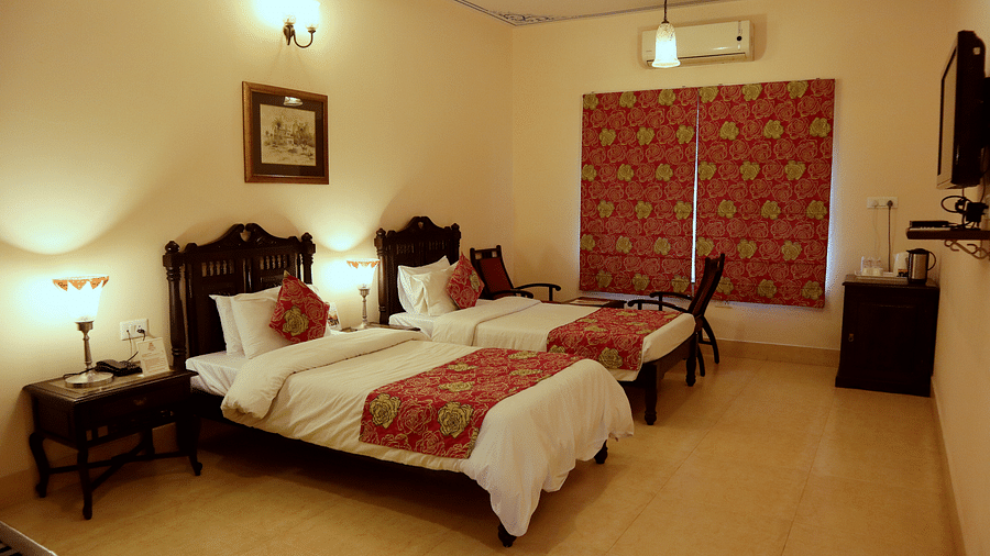 Twin beds with beautiful red bedsheets and red pillow covers at Junior Suite at Suryaa Villa Jaipur