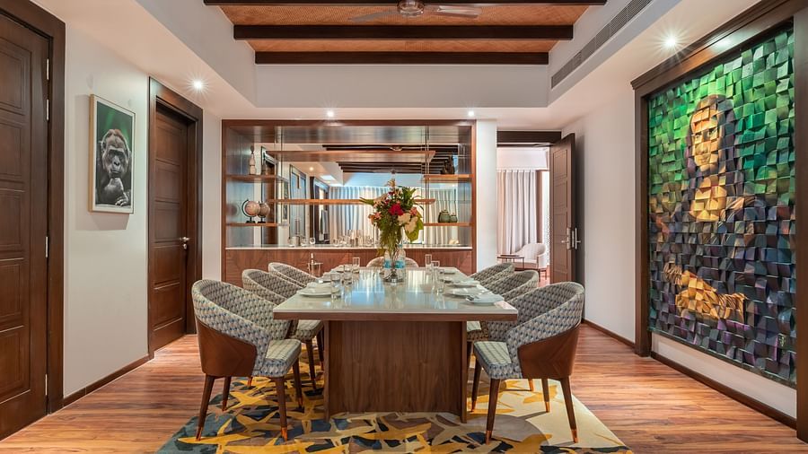A dining table with chairs and a picture of Mona Lisa on the side at the Grand Suite- The Ananta Udaipur