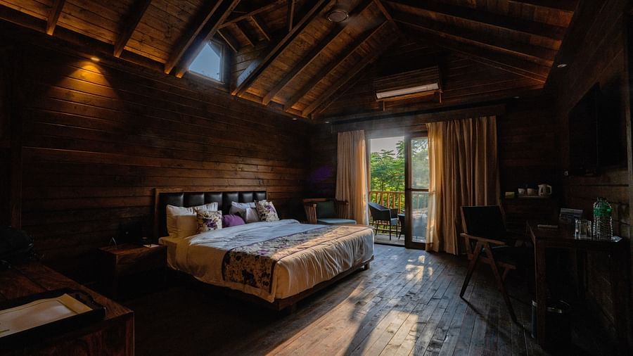 The warm and cosy wooden bedroom inside the cottages - The Ananta, Udaipur 