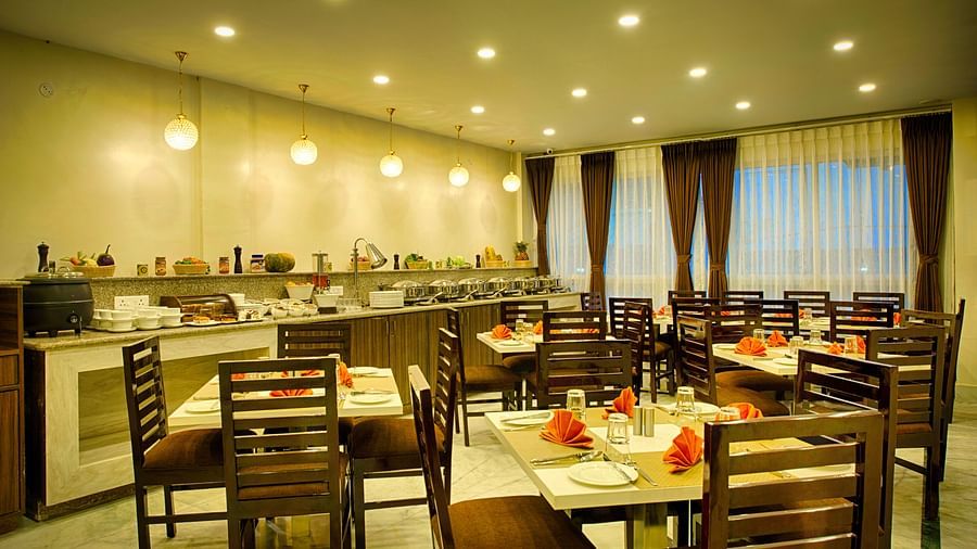 interior of a restaurant with indoor seating and buffet section and posh interior - The aryan regency