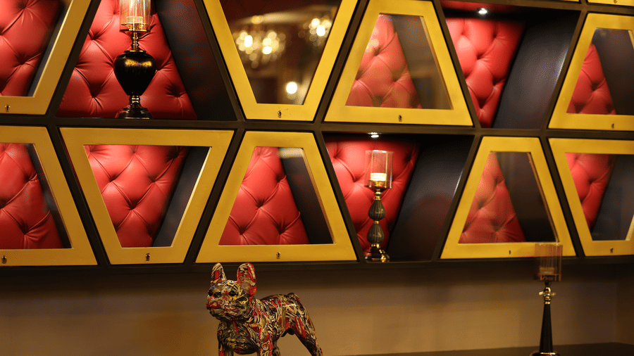 Wall at The Beatle Hotel, Powai, with red, tufted, triangular velvet recesses holding decorative objects.