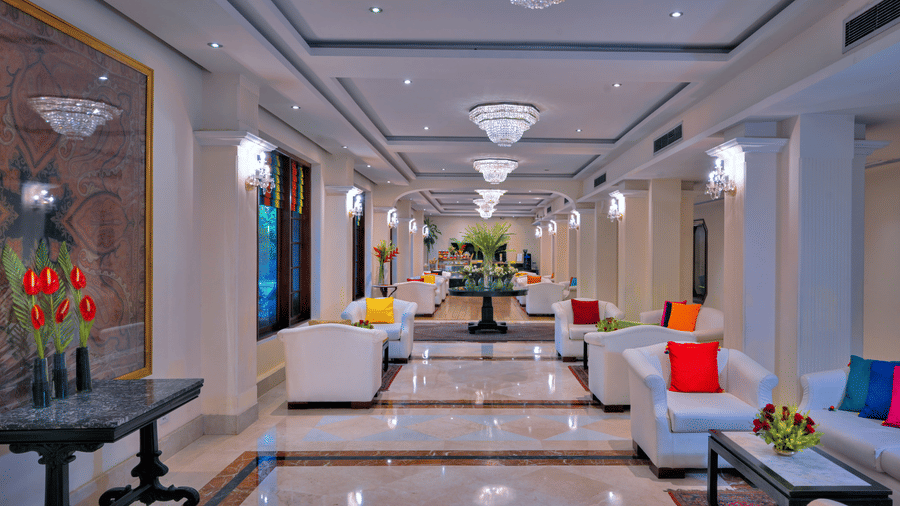 A lounge at The Clarks Varanasi, with sofas, plants and lights.