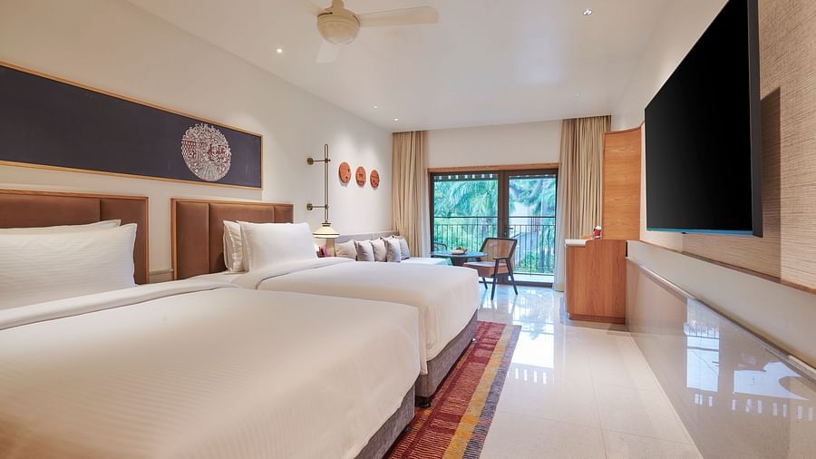 A room with two beds, TV, a balcony overlooking greenery at The Dukes Retreat.