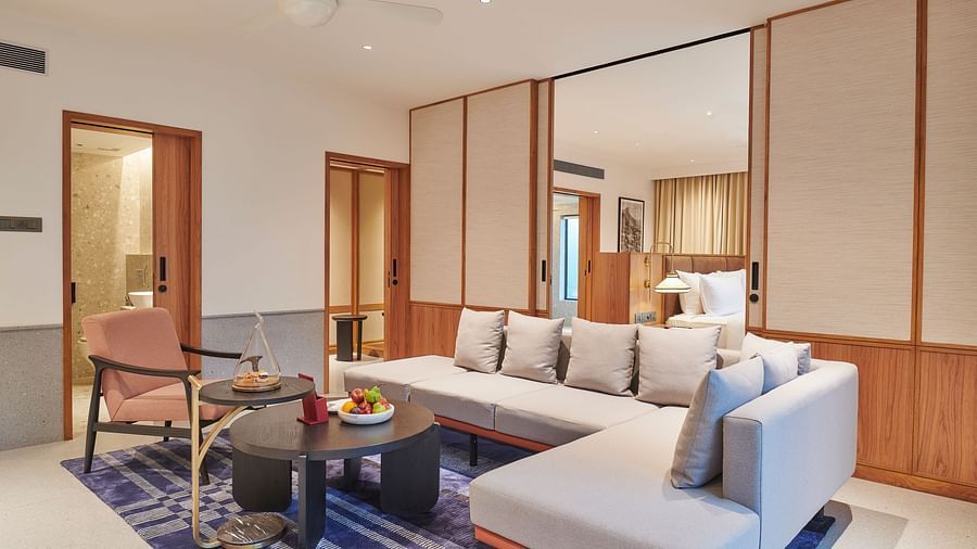 A seating area with a grey sofa , a small round table and blue carpet at The Dukes Retreat.