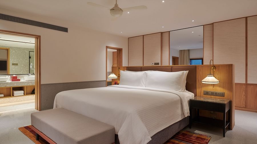 A comfortable bed with a side table on a decorative carpet at The Dukes Retreat.