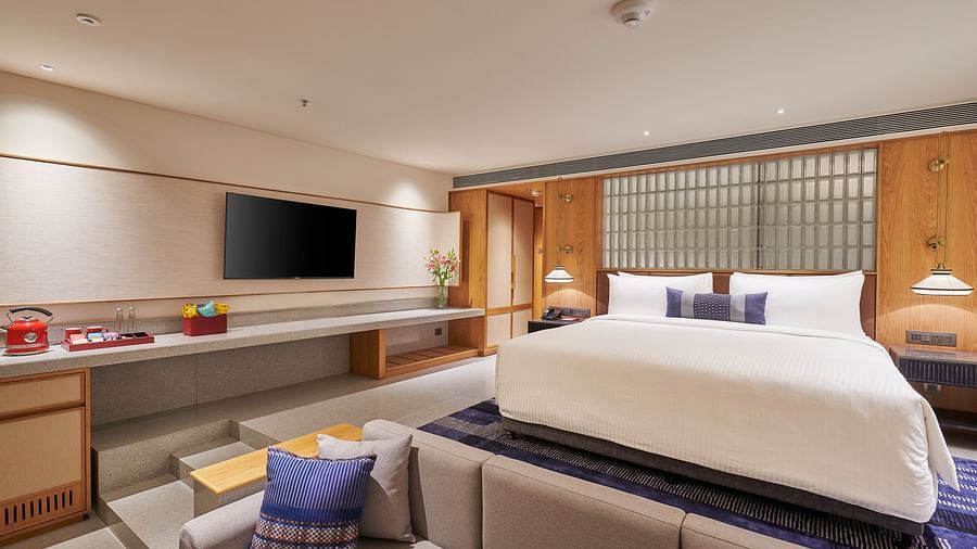 Image of a bedroom with a television, king side bed and a foot sofa in front of the bed  at The Dukes Retreat.