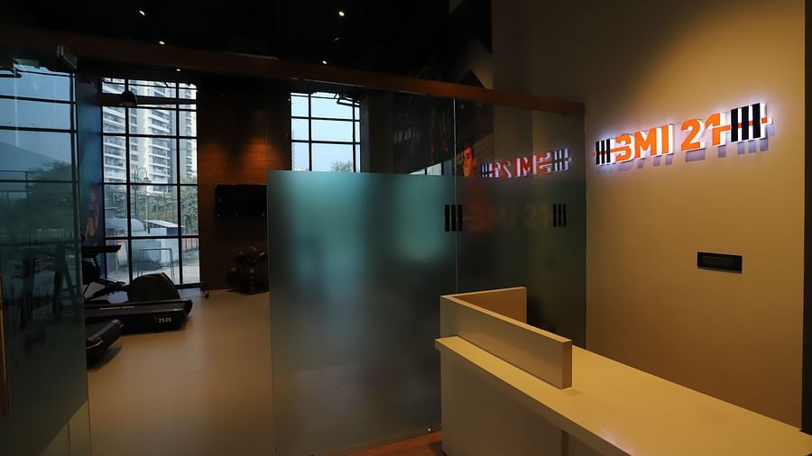 The entrance or reception area of a facility at The Gaurs Sarovar Premiere, possibly a gym or recreational area, with glass partitions and a reception desk.