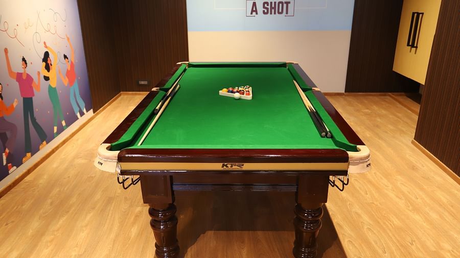 Interior of the billiards room at The Gaurs Sarovar Premiere, showcasing a green billiards table and surrounding space.