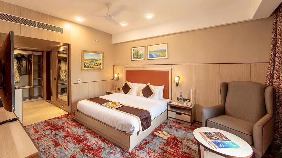 Elegant king bedroom with seating area at The Lalita Grand hotel