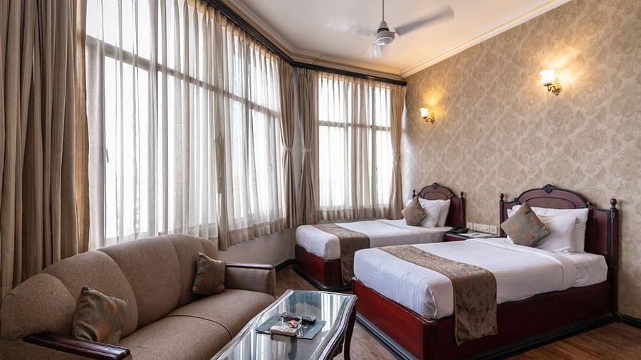 An image of a large bedroom, with two large  windows, and a sitting area  - The Lindsay