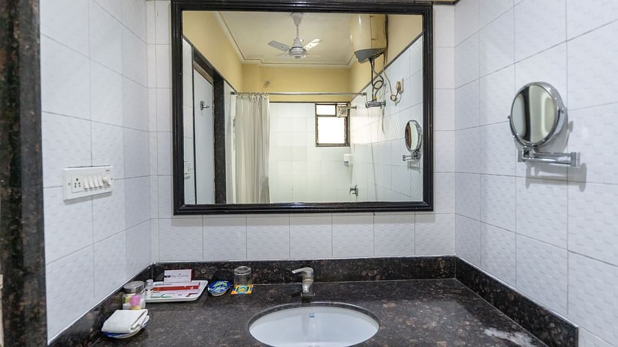 An image of a  bathroom with huge mirror above the sink and faucet - The Lindsay