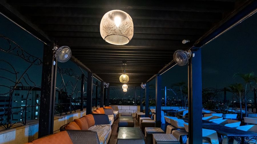 A huge sitting area on the deck that has a sofa, stools, and a centre table in each setting - The Lindsay