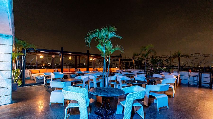 An image of an outdoor sitting area with multiple chairs and tables - The Lindsay