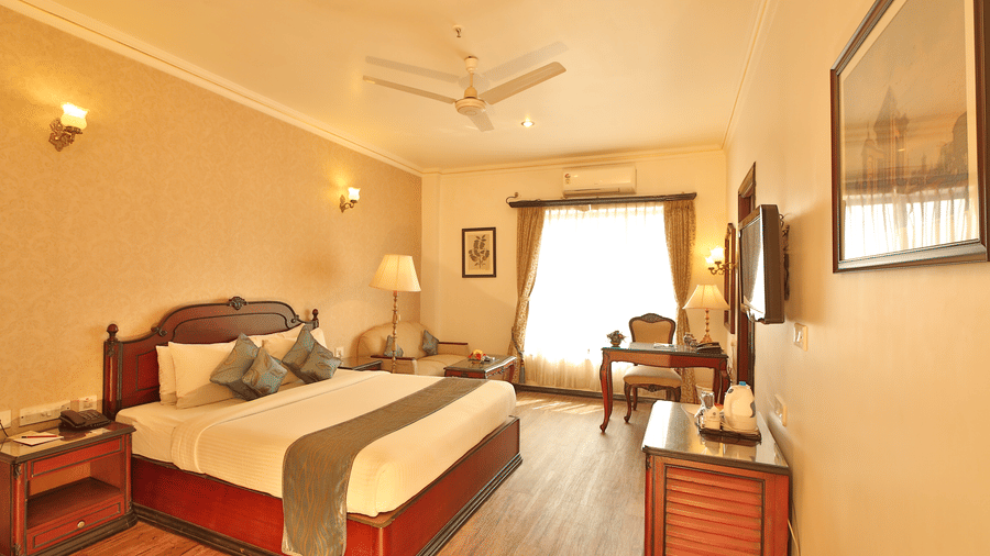 Well-appointed guest room featuring twin beds, wooden flooring, and warm lighting for a comfortable stay at The Lindsay.