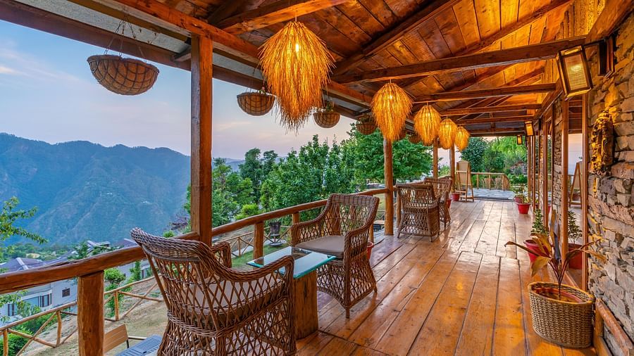 A evening view of the balcony in our restaurant with ambient lamps hanging from the ceiling illuminating the area - The Manor Luxury Hotel, Shimla
