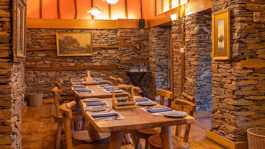 A well-lit restaurant space with a two tables placed side by side - The Manor Luxury Hotel, Shimla