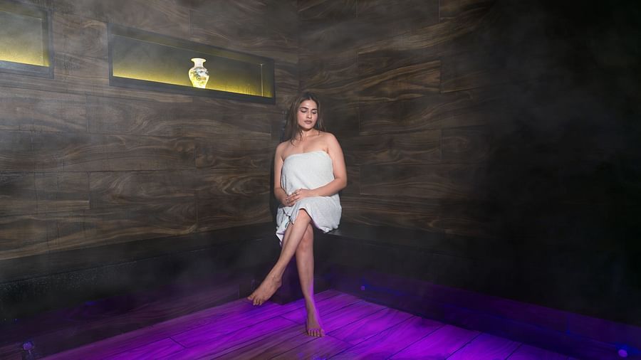An image of a woman sitting in a counter top of a Sauna Room -  The Manor Luxury Hotel, Shimla