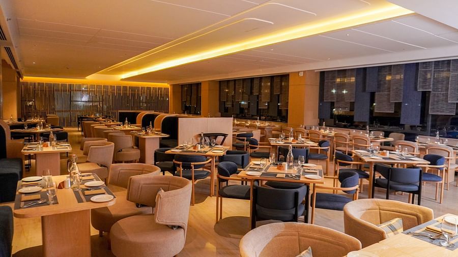 Expansive restaurant view shows soft overhead lighting, diverse seating with booths and tables, and a warm ambience - The Orchid Hotel Chandigarh 