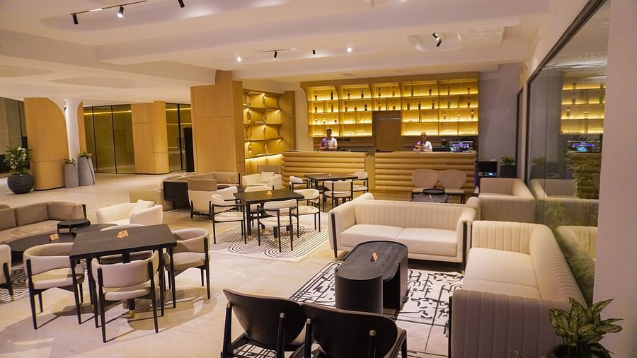 Alternative perspective of the hotel restaurant showcasing numerous tables, a well-stocked bar with warm lighting, and a relaxed yet sophisticated dining environment - The Orchid Hotel, Chandigarh