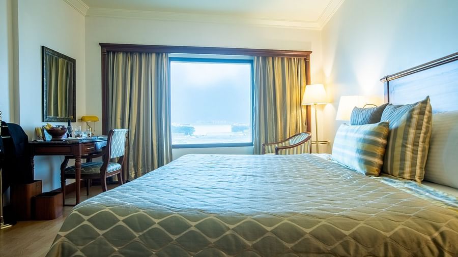 room with a king size bed overlooking the city - The Orchid Hotel Mumbai Vile Parle