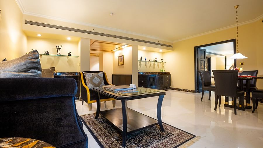 living room with a cushy sofa and dining table at our presidential suite - the orchid hotel mumbai