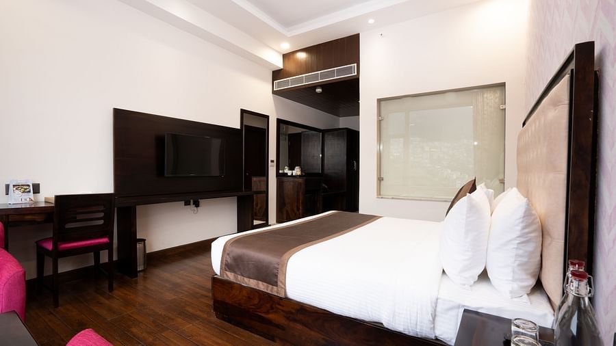  A glimpse of the Rooms in Shimla featuring a sizeable bedroom with modern amenities - The Orchid Hotel Shimla