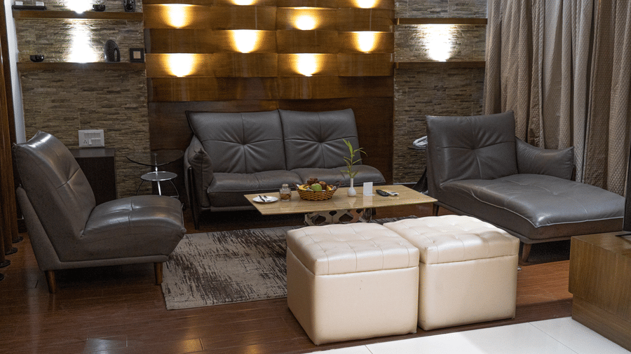 Separate living room in the Suite seen with a spacious seating area featuring upholstered leather sofas, a leather lounge chair, and a centre table at Sarovar Portico, Bhubaneswar.