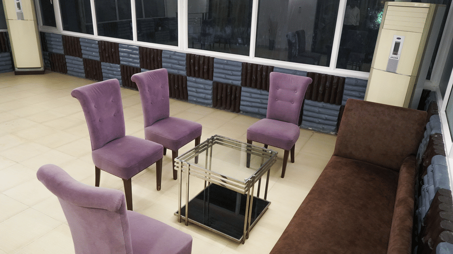Separate seating area in the Suite of Sarovar Portico, Bhubaneswar, furnished with upholstered chairs and a multi-seating sofa placed around a centre table.