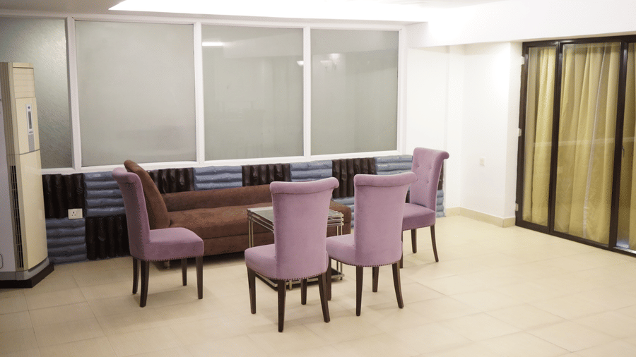 Separate seating area in the Suite of Sarovar Portico, Bhubaneswar, furnished with upholstered chairs and a multi-seating sofa placed around a centre table.
