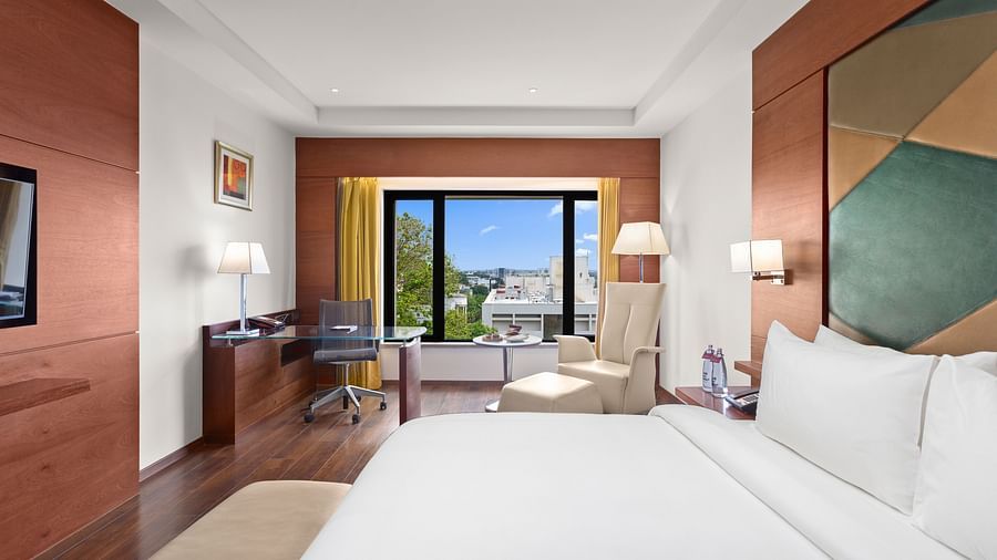 Executive Room Pool View with a cozy bed, a chair in the corner, and a view from the window at The Residency Towers Coimbatore
