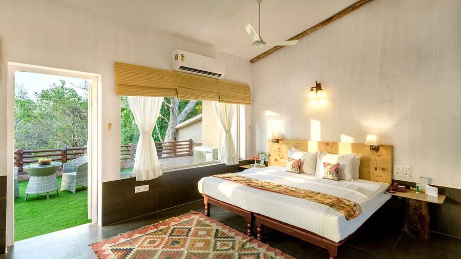 A shot of Premium Riverview Suite with a bed and glass window | The Riverwood Forest Retreat, Pench